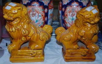 A pair of Chinese ochre glazed pottery dogs of Foo.