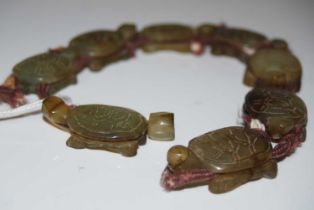 A carved green stone terrapin/ tortoise necklace formed from eight carved green stone terrapins