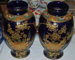 A pair of Japanese Satsuma style blue ground vases with richly gilded details of prunus blossom.