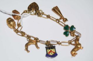 A 9ct gold charm bracelet suspending six assorted yellow metal and gold charms, and a Sterling