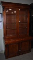 A Victorian mahogany glazed two part bookcase, the moulded cornice above two glazed doors opening to
