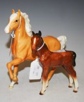 A Beswick figure of a caramel coloured horse, together with another ceramic figure of a foal.