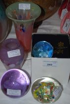 A group of assorted glassware comprising three Caithness Glass paperweights, another paperweight,