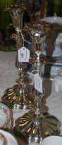 A pair of white metal ornate candlesticks engraved 'HL'.