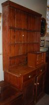 A 20th century pine two-part dresser, the upper section with three open shelves, the lower section