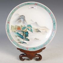 A Chinese porcelain famille rose dish, 20th century, decorated with pavilions and pine trees in a
