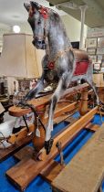 A vintage childs rocking horse mounted to a pine base.