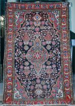 A Persian rug, early 20th century, the rectangular blue ground field centred with a large lozenge