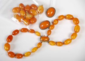 A group of vintage butterscotch amber to include a gilt metal mounted double strand bracelet, a pair