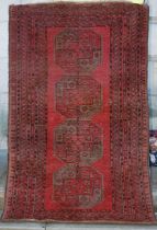 A Persian rug, mid 20th century, the rectangular madder field decorated with four octagonal shaped
