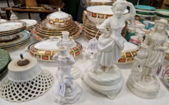 A group of antique white porcelain comprising a table centrepiece in the form of a lady carrying a