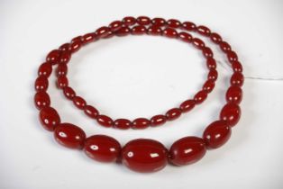A vintage red amber type graduated bead necklace, gross weight 62.9 grams.
