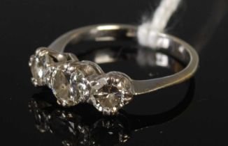 A white metal and diamond three stone ring, set with three round brilliant cut diamonds, stamped '