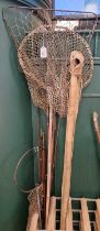 A collection of assorted vintage fishing rods and nets.