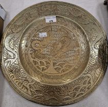 A Chinese brass charger with incised details of dragons.