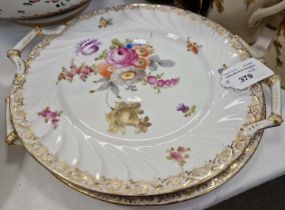 A pair of Dresden porcelain twin handled cake plates with floral design and gilded borders.