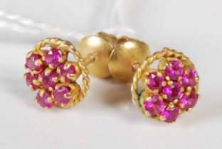 A pair of yellow metal and synthetic ruby flower stud earrings.