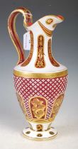 A Bohemian opaque white and ruby glass jug with richly gilded details.