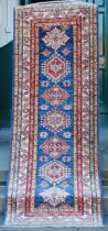 A Persian runner, 20th century, the central blue ground decorated with seven foliate medallions