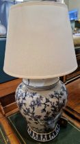 A decorative blue and white lamp decorated with prunus blossom in the Chinese taste.