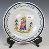A late 19th century French pottery plate decorated with a lady holding an umbrella within blue and