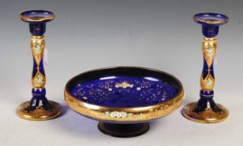 A Continental blue and gilt glass bowl together with a pair of matching candlesticks.