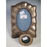 An early 20th century Birmingham silver photograph frame, the shaped surround with oval aperture and