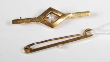 A vintage white and yellow metal bar brooch centred with a single pearl, stamped '15ct', together