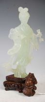 A boxed Chinese green stone figure of a lady holding a fan on carved and pierced wood stand,