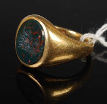 An 18ct gold signet ring with blood stone insert, carved with the crest of Mackinnon, size 'R',