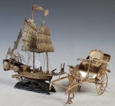 A Chinese white metal model of a three-masted ship on carved and pierced wood stand, 19cm high,