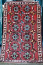 A Persian Ghoochan rug, the rectangular madder ground decorated with twelve octagonal shaped