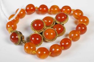 A vintage amber bead bracelet with gilt metal clasp, together with a pair of matching triple