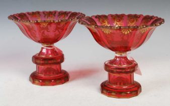 A pair of late 19th century ruby glass pedestal bowls, each with gilded decoration, 17cm diameter
