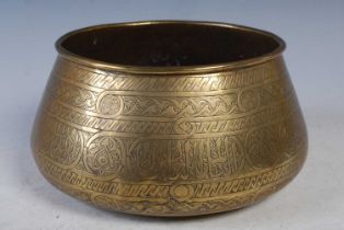 A Cairoware engraved brass bowl, late 19th/ early 20th century, incised with panels of Kufic Script,