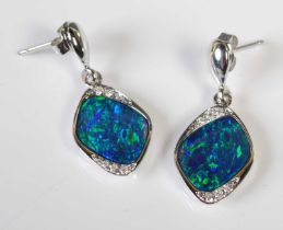 A pair of white metal, opal and diamond set drop earrings, each set with a lozenge shaped opal