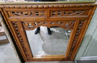 An ornately carved and pierced wood rectangular wall mirror, 103cm x 90cm.