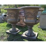 Pair of cast iron urns on wooden bases - Approx height: 60cm