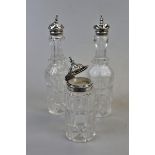 Cut glass condiment bottles with hallmarked silver tops