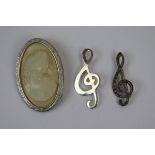 2 silver music note brooches together with a silver framed brooch