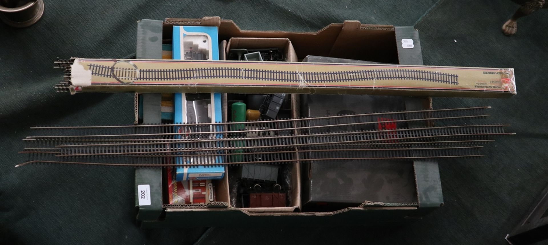 Assorted model train components including track, trains, carriages, controller etc