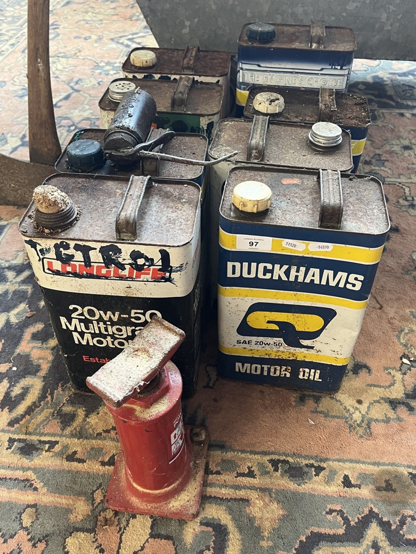 Collection of old cans together with a smaller can and bottle jack