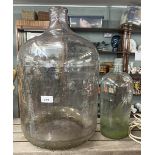 Large glass carboy together with a smaller carboy