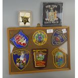 Collection of framed American law enforcement patches together with a Sherriff badge