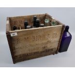Collection of vintage bottles in a wooden crate marked R.M. Bird and Co. Stratford Upon Avon