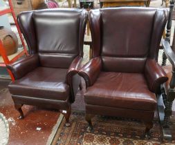 Pair of leather wing backed armchairs