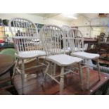 A pair of white painted elbow chairs together with three similar standard chairs