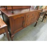 An early 20th century mahogany sideboard having three centre drawers flanked by cupboard doors on