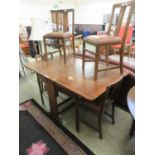 An early 20th century oak drop leaf dining table along with a set of four contemporary chairs