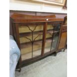 An early 20th century mahogany veneered bow front glazed two door cabinet on cabriole supports